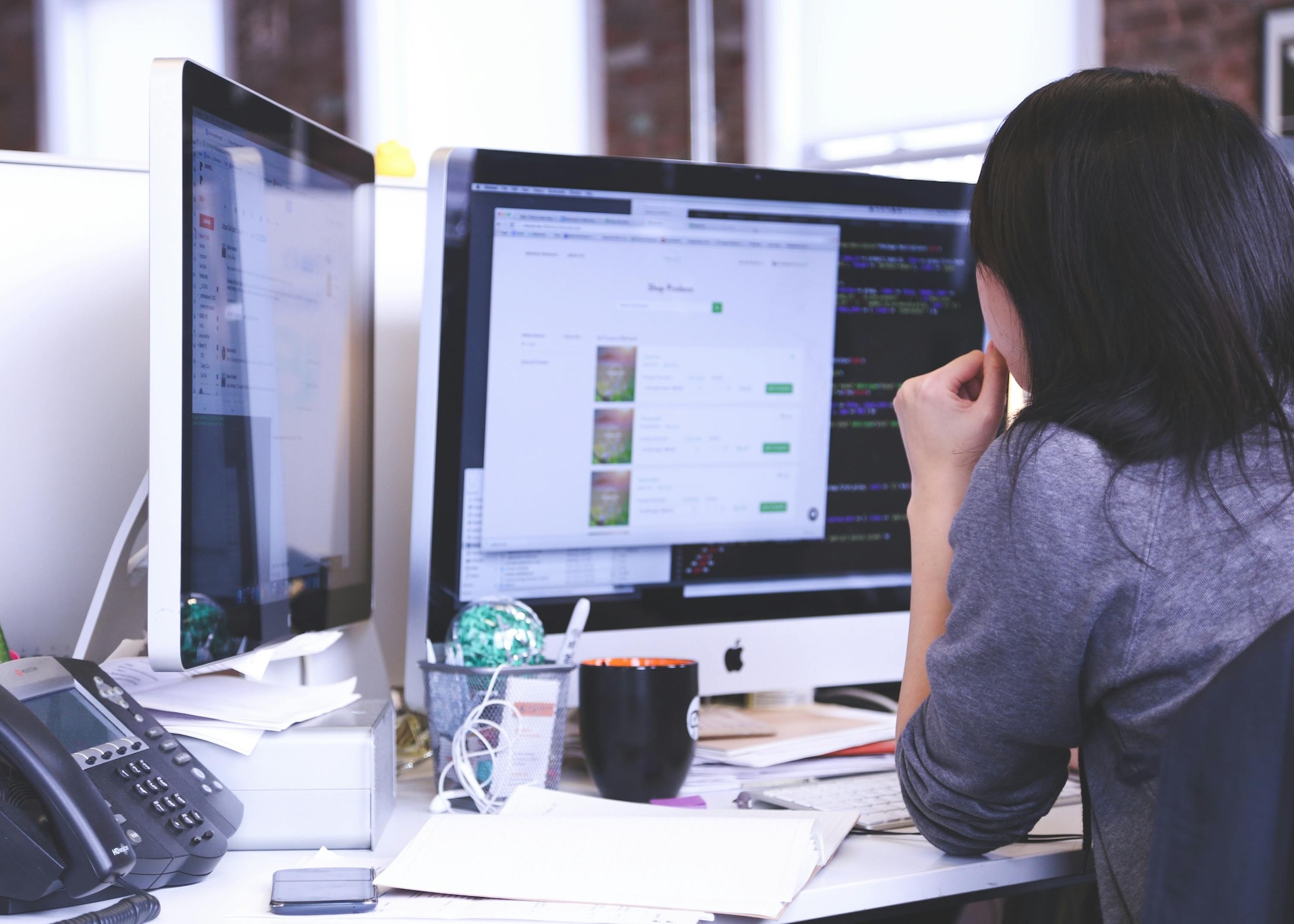 A Runwell team member working on the platform at a multi-monitor workstation